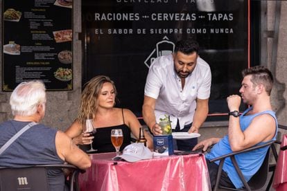 Una camarero atiende a un grupo de clientes en Madrid, el 11 de agosto.