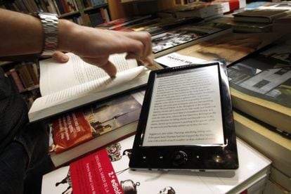 Un libro electr&oacute;nico y otro en papel, en una librer&iacute;a de Madrid.