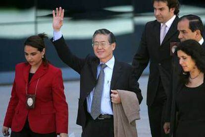 El ex presidente peruano Alberto Fujimori saluda al ser trasladado hasta una prisión por la policía.