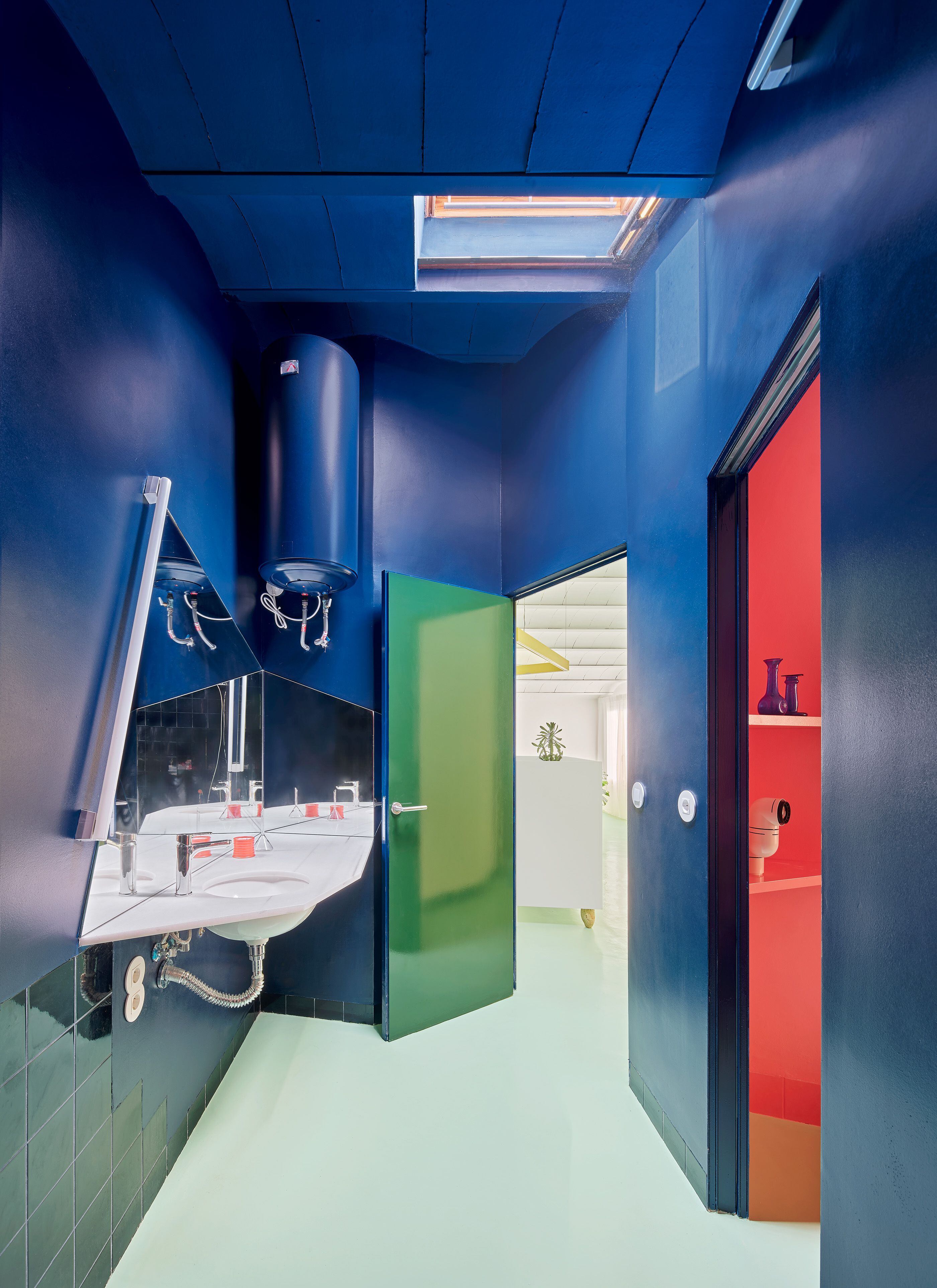 El baño, azul eléctrico, conecta con las dos estancias principales de la vivienda: el salón y el dormitorio.