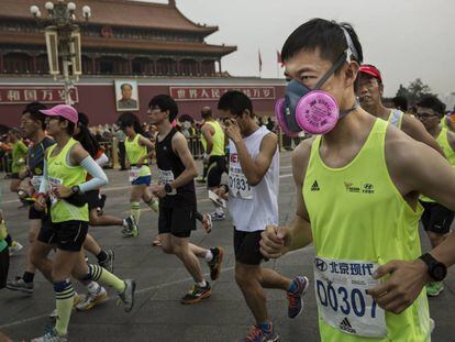 Un hombre corre en la marat&oacute;n de Pek&iacute;n de 2015 con una mascarilla anticontaminaci&oacute;n.