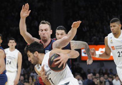 Campazzo cubre el balón, ante el acoso de Huertas.