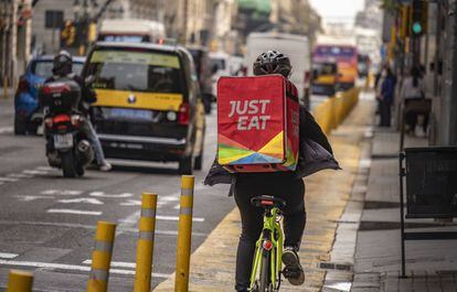 Un repartidor de Just Eat cruza en bicicleta la Via Laietana de Barcelona para entregar un pedido.