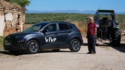 Javier Bollaín, alcalde de Illán de Vacas, con el coche eléctrico de 'carsharing' instalado en su pueblo.