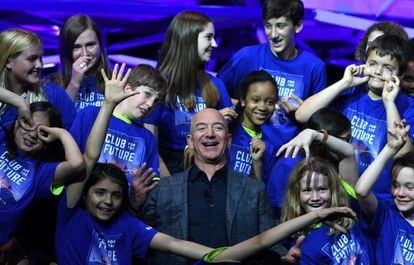El fundador y presidente de Amazon, Jeff Bezos, posa con niños del Club del futuro en un evento de Blue Origin.