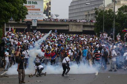 Un grupo de manifestantes se enfrenta con la policía hoy en Caracas.