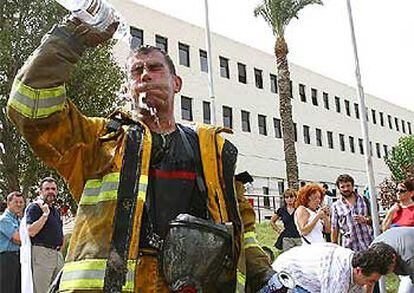 Un bombero se refresca en el hospital de la Vega Baja, tras el incendio que se ha declarado hoy en el centro sanitario.