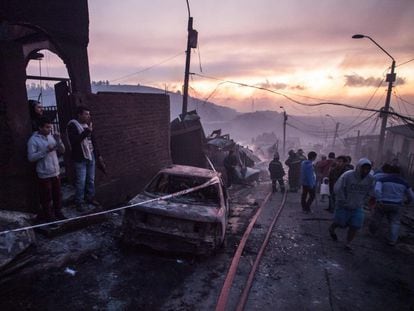 El puerto chileno de Valparaíso, a 120 kilómetros de Santiago y compuesto por 42 cerros, se enfrenta de nuevo a una tragedia a causa de las llamas. En la imagen, un grupo de vecinos observan el estado de las viviendas.