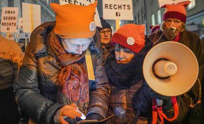 A la derecha, Caroline Koczan repasa las letras de su lema antes de usar el megáfono durante la manifestación contra el Gobierno, en Viena, el 24 de enero.