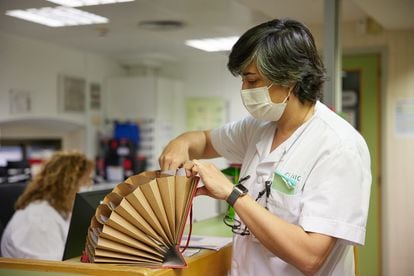 Ana Alonso, coordinadora asistencial de Patología de Hígado, guarda en una carpeta documentación de pacientes ingresados.