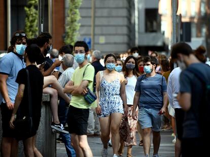 Varias personas caminan con mascarilla por una calle del centro de Madrid.