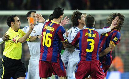Sergio Ramos da un manotazo a Puyol durante el encuentro.