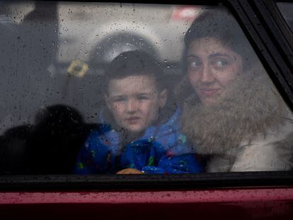 Una madre junto a su hijo miran por la ventana de su coche a su llegada al centro de recepción de refugiados en Zaporizyia.