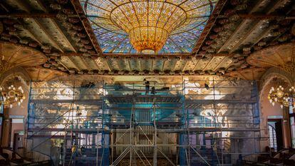 Un operario trabaja en el Palau de la Música durante la restauración del conjunto escultórico del escenario.