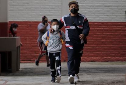 Un padre con su hijo. ambos con mascarilla, en el interior de una escuela luego de que se regresara a las aulas en Ciudad de México