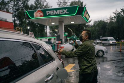 Un trabajador sostiene una bomba de combustible en una gasolinera de Petróleos Mexicanos en Naucalpan, Estado de México, en agosto de 2022.