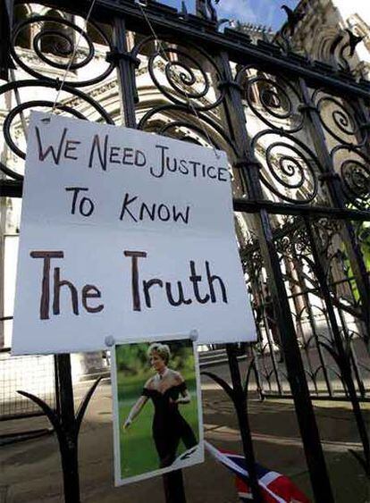 Una foto de Diana y un cartel pidiendo justicia cuelgan de la valla que rodea el Tribunal Superior de Justicia de la capital inglesa, donde se celebra la vista preliminar por la muerte de la princesa de Gales y su novio Dodi Al Fayed.