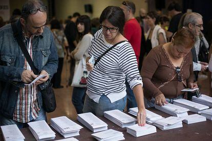 Electores cogen papeletas en una jornada electoral.