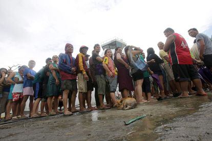 Filipinos hacen cola para conseguir víveres.
