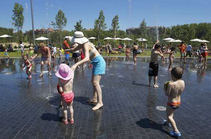 Gente refrescandose en una fuente de Madrid R&iacute;o.