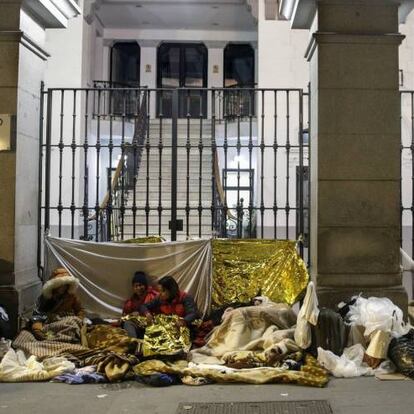 Un grupo de solicitantes de asilo se dispone a pasar la noche frente a la sede del Samur Social, en el centro de Madrid.