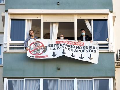 Los vecinos de Carlos Haya, 65, en Málaga, descuelgan la pancarta en contra de la apertura de una casa de apuestas en los bajos, tras conseguir que ese negocio no se instale allí.