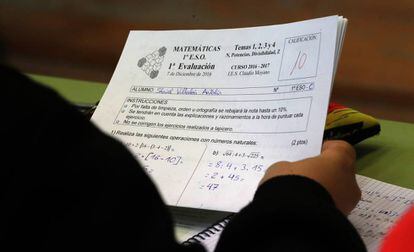 Un alumne de 1r d'ESO amb un examen de matemàtiques.