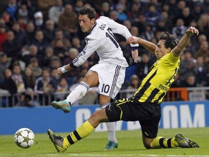 Özil golpea el balón ante el jugador del Borussia Mats Hummels.