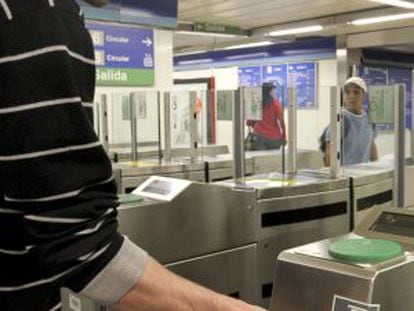 Un usuario introduce su billete en el torno de entrada de una estación del metro de Madrid.