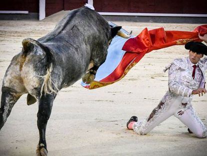 Francisco Montero, de rodillas en la puerta de chiqueros, con el capote de paseo.