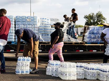 La población de Jackson recibe botellas de agua.