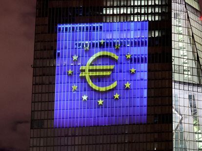 El símbolo del euro y la bandera de la UE, sobre la fachada de la sede del BCE en Frankfurt.