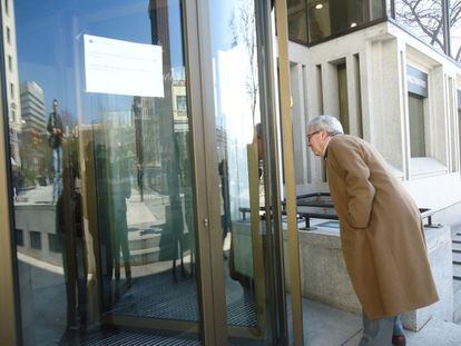 Un cliente observa el interior de la sucursal cerrada del Banco Madrid ubicado en la Plaza de Colón.