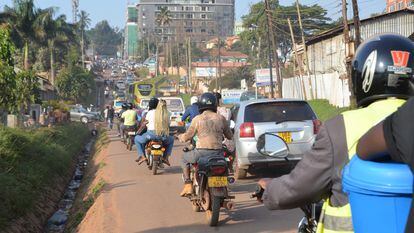 Mototaxis, conocidos localmente como 'boda-boda', pasan junto a vehículos Kampala (Uganda)