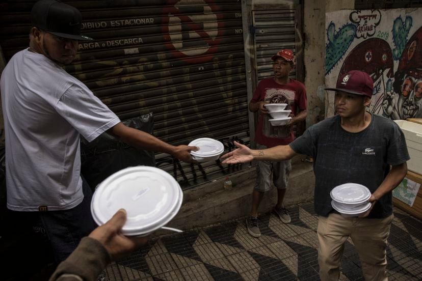 Miembros del Movimiento Estatal de la Población Callejera distribuyen almuerzos en loncheras a personas sin hogar en la región central de São Paulo, Brasil.