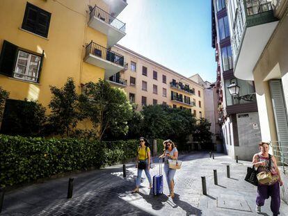 Tres mujeres caminan por la calle Señores de Luzón a la altura de los edificios número 4 y 6, en el centro de Madrid.