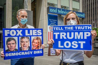 Dos manifestantes protestan ante el edificio de News Corp, el grupo fundado por el magnate Rupert Murdoch.
