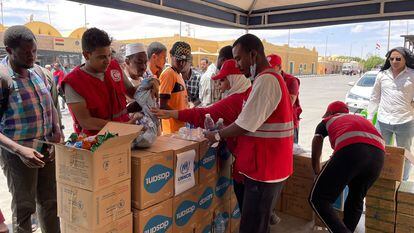 Un grupo de sudaneses recibe agua y comida de ACNUR en el puesto fronterizo de Qostol, entre Sudán y Egipto.