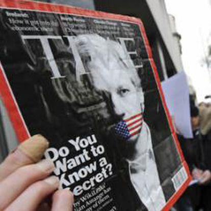 Un manifestante la portada de la revista "Time" con la fotografía del fundador de Wikileaks, Julian Assange, a las puertas del tribunal de la City de Westminster