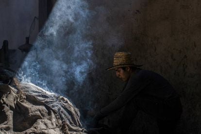 Un operario del palenque mezcalero Macurichos, en plena faena de horneado de pencas.