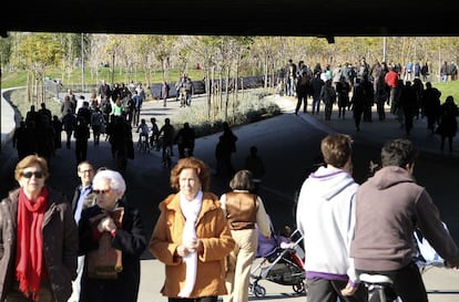 Un domingo en Madrid Río. Gente de todas las edades pasea por los jardines, que ya está a la altura de la Casa de Campo, el Retiro o Sol en las preferencias para caminar en fin de semana. El paisaje se ha dividido en tres zonas -bosque mediterráneo, atlántico y rivera- con árboles distintos en cada una de ellas.