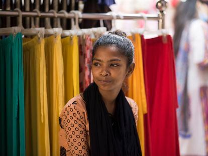 Sumaya, una niña de 14 años, frente a la tienda de ropa donde trabaja en Bangladésh.