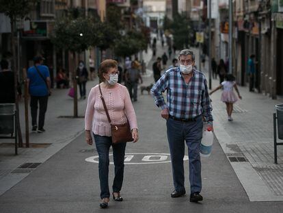 Dos personas pasean por una calle de L'Hospitalet de Llobregat (Barcelona).