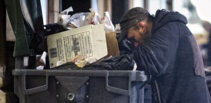 Dos personas buscan comida en una calle de Barcelona.