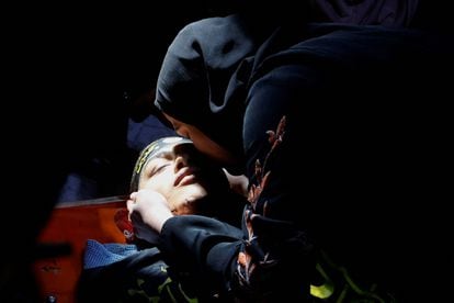 Una mujer besa a una víctima de los tres, de un ataque israelí con drones, durante su funeral en el campamento de refugiados de Jenin, en la Cisjordania ocupada por Israel.