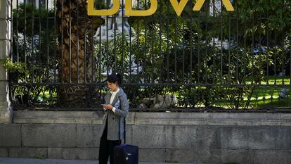 Una mujer en frente de un edificio del BBVA en Madrid.