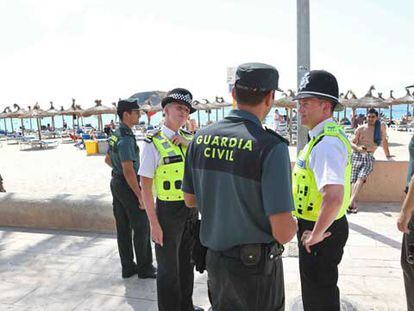 Miembros de la Guardia Civil y 'Bobbies' británicos patrullan por la playa de Magaluf.