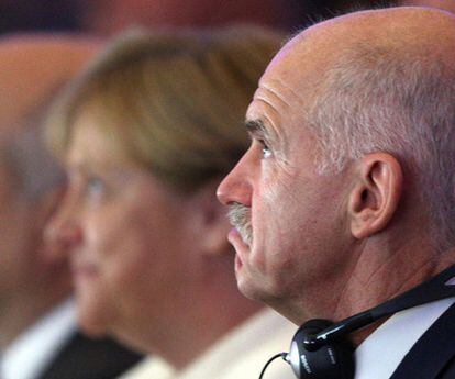 El primer ministro griego, George Papandreu, y la canciller alemana, Angela Merkel, durante el encuentro celebrado por la patronal alemana en Berlín.