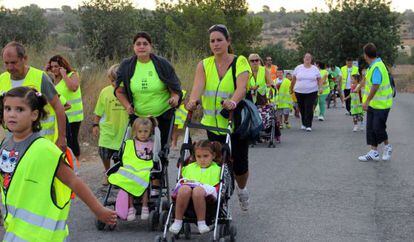 Madres, padres y alumnos de La Pobla de Vallbona, de camino al colegio al tiempo que protestan por la falta de autob&uacute;s.