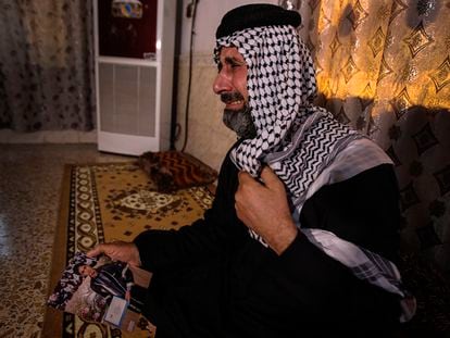 Jaseb al Heliji, asesinado el pasado miércoles, llora mientras muestra una foto de su hijo, en su casa de Al Amara, el verano pasado.